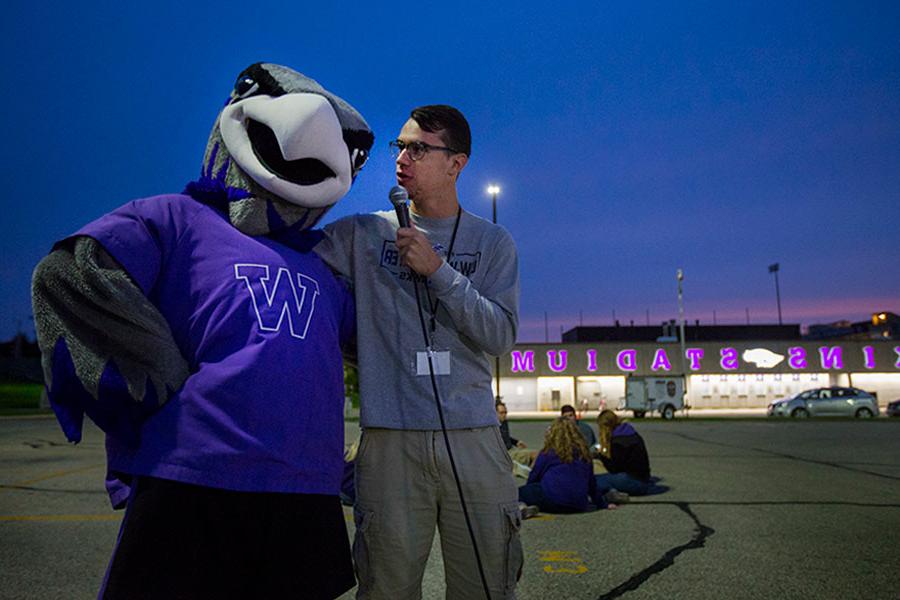 A student interviews Willie Warhawk outside of Perkins Stadium.