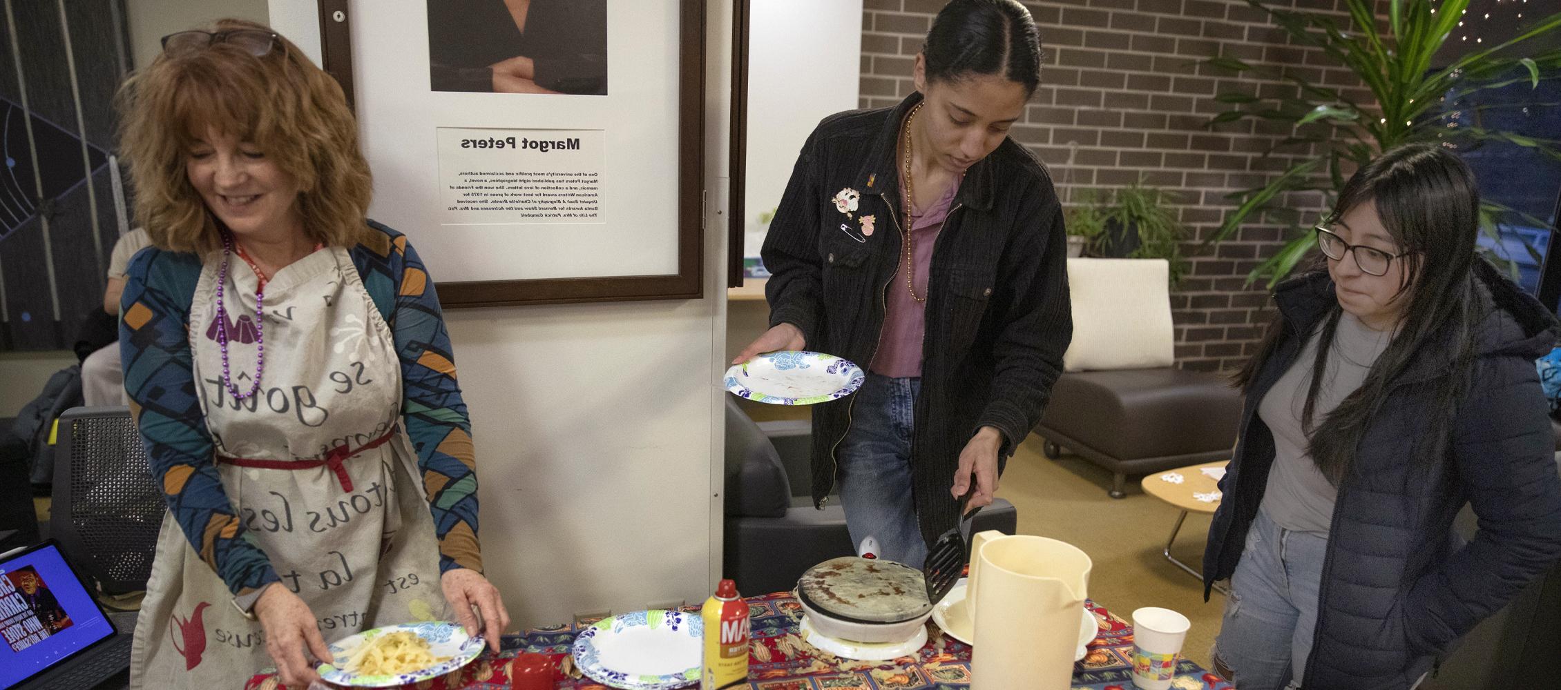 A faculty member and students make crepes.