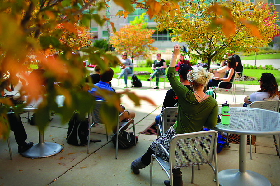 Students have class outside among fall colors.