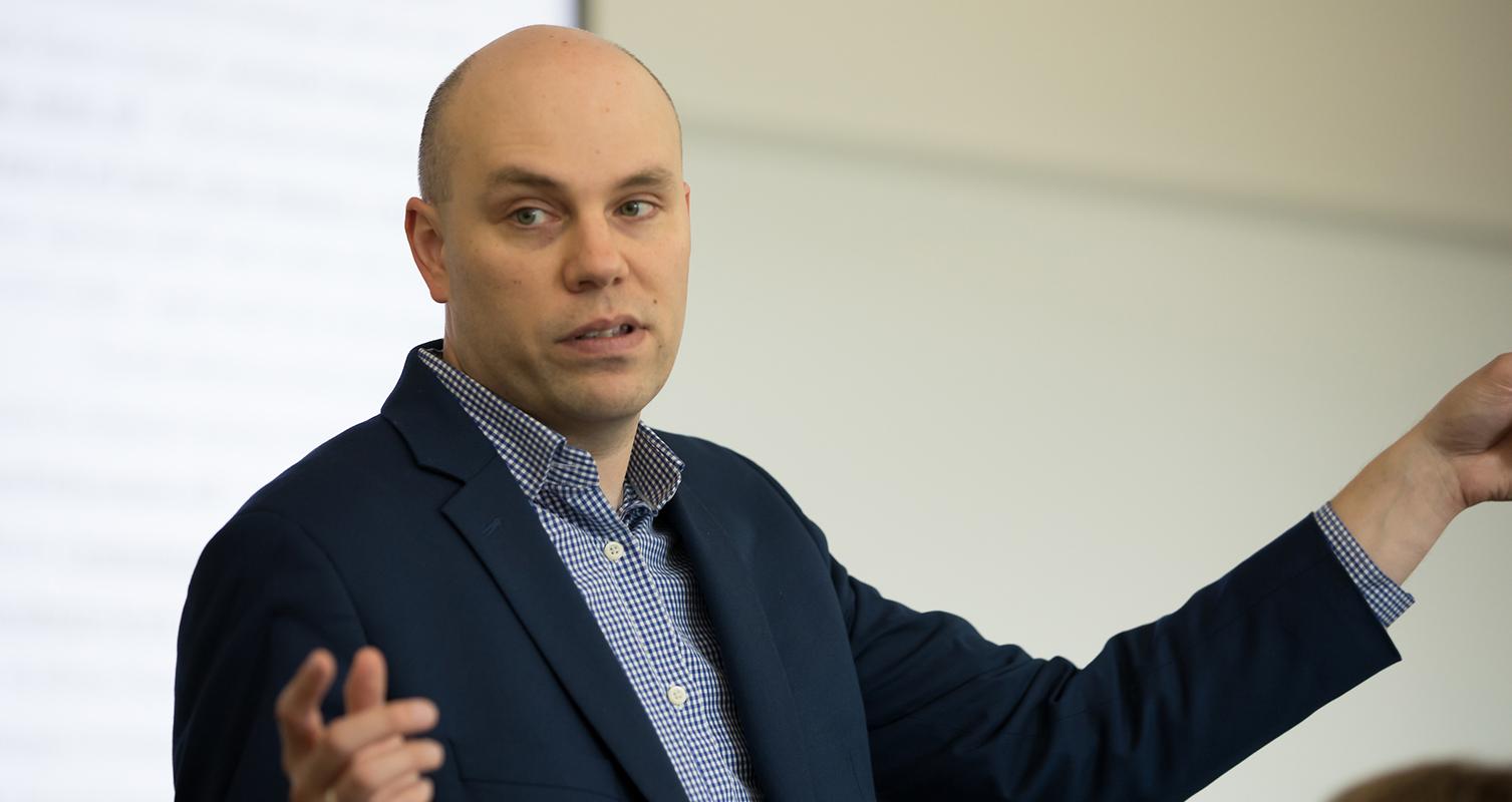 Andy Dahl, assistant professor of marketing, talks with students during one of his classes in Hyland Hall