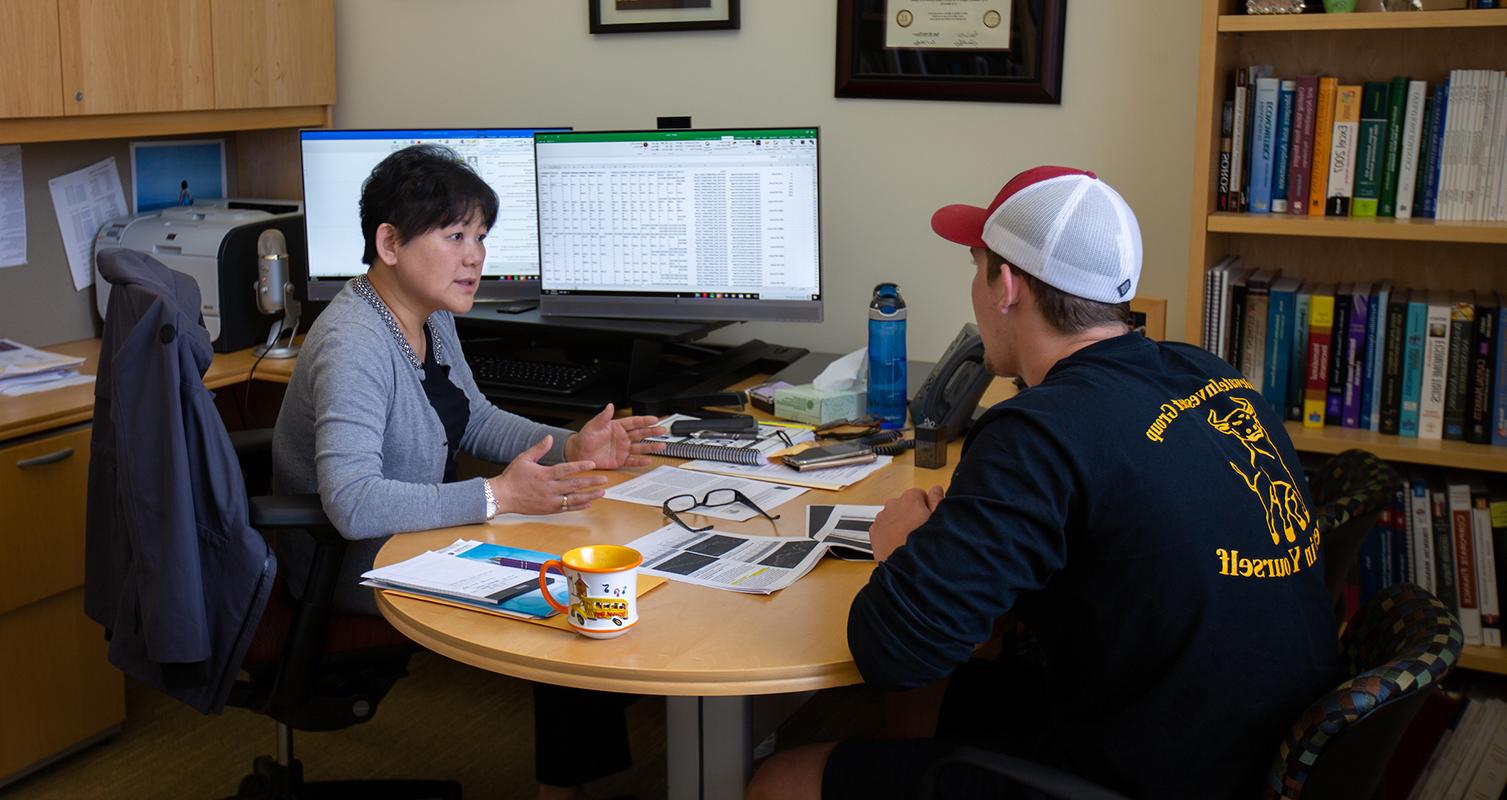 Professor Linda Yu talks with a student