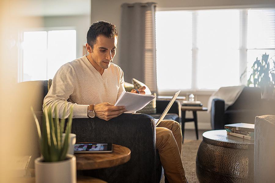 Man studying at home with laptop and tablet