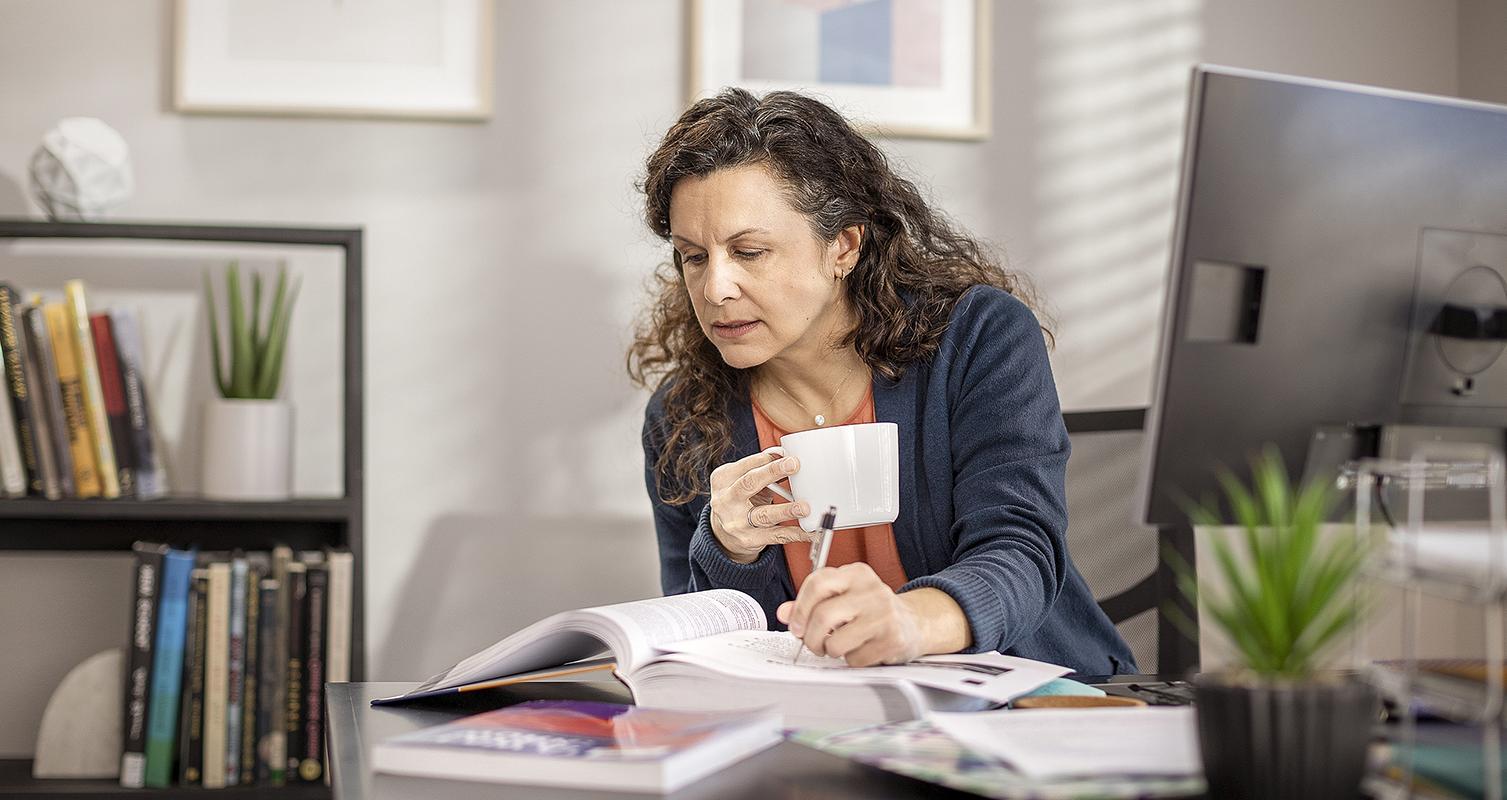 Woman studies at table in home