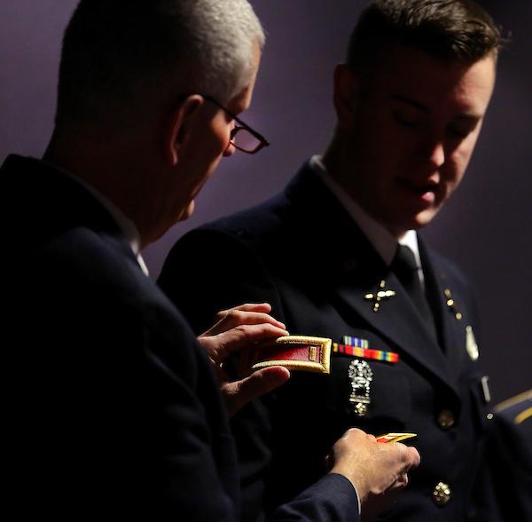 Student in uniform receiving a badge