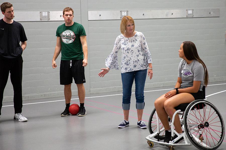 Kathleen Happel speaks with students in a gym on the 足彩平台 campus.