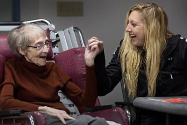 Two community members laughing and holding hands